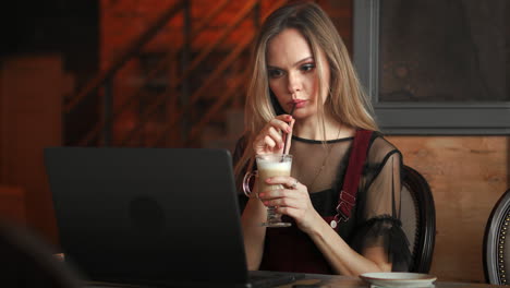 Focused-attentive-woman-in-headphones-sits-at-desk-with-laptop,-looks-at-screen,-makes-notes,-learns-foreign-language-in-internet,-online-study-course,-self-education-on-web,-consults-client-by-video